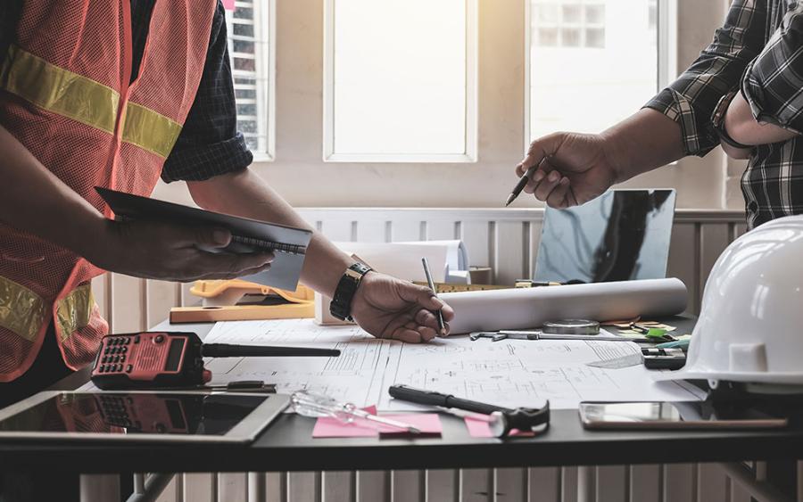 Engineer and surveyor meeting together with plans