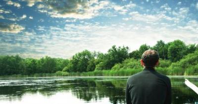 Man pondering on lake